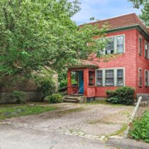 Front exterior image of the East Watertown MA Multifamily at 7 Oliver Rd Watertown MA 02472 surrounded by lush landscape with a covered front porch and off street parking listed exclusively by Tamela Roche Realtor.